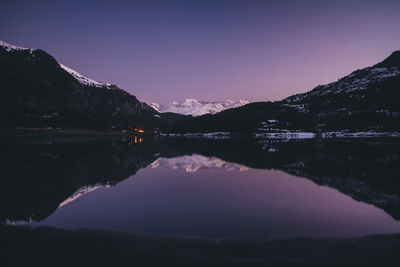 Scenic view of lake and mountains against sky during sunset