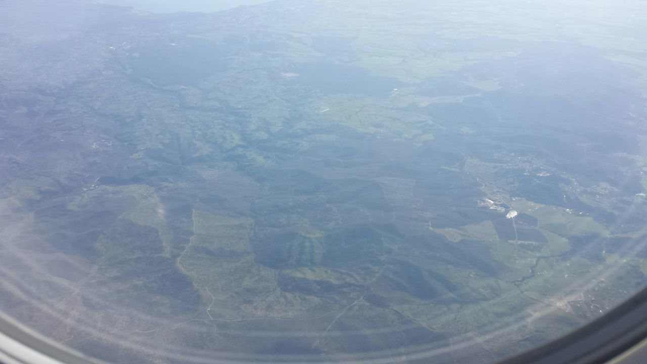 aerial view, transparent, landscape, airplane, window, scenics, high angle view, nature, beauty in nature, glass - material, tranquility, water, tranquil scene, backgrounds, air vehicle, indoors, no people, day, full frame, transportation