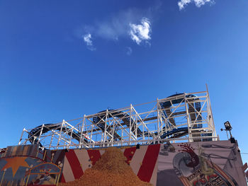 Low angle view of ferris wheel against blue sky