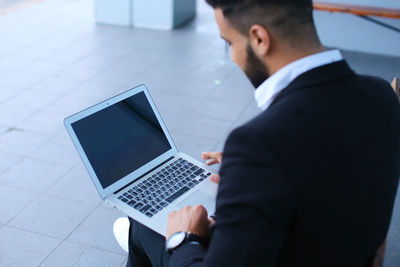 High angle view of businessman using laptop outdoors