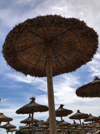 Low angle view of umbrellas on beach against sky