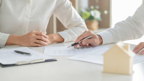 Midsection of couple holding hands on table