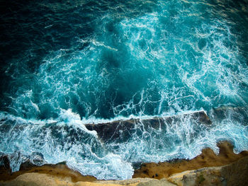 Aerial view of sea wave crashing on shore