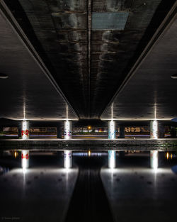 Illuminated bridge over water at night