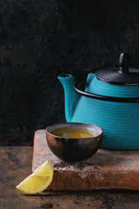 Tea with lemon on table against wall