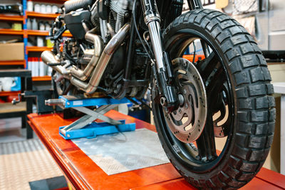 Close up of front wheel tyre and brake disk of custom motorbike on workshop