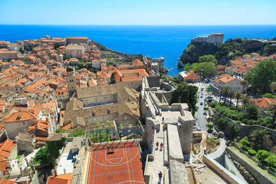 High angle view of houses by sea against sky