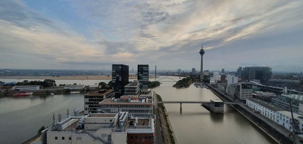 High angle view of buildings by river against sky