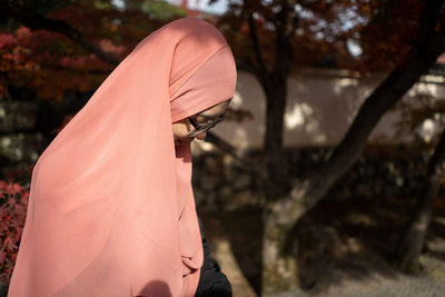 Close-up of woman standing against tree