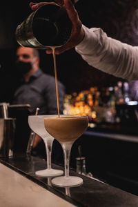 Midsection of man pouring wine in glass