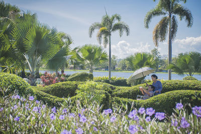 Woman pushing wheelchair with man in park