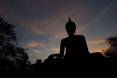 Low angle view of silhouette statue against sky at sunset