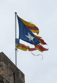 Low angle view of flag flags against sky