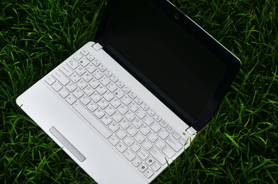 High angle view of laptop on grassy field