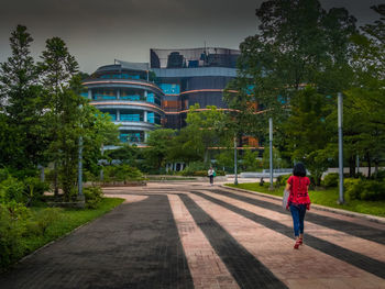 Rear view of woman walking on road in city