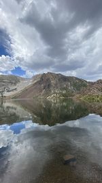 Scenic view of lake by mountain against sky