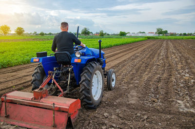 A farmer on a tractor looks at the farmer's field. work on the plantation, preparing the soil 