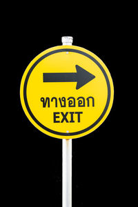 Close-up of road sign against black background