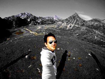 Portrait of man wearing sunglasses standing on mountain