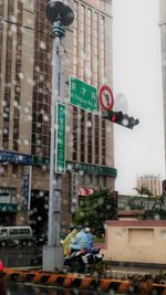 Road sign against buildings in city