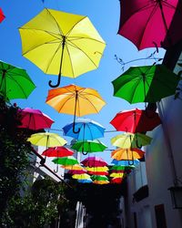 Low angle view of umbrellas hanging against sky