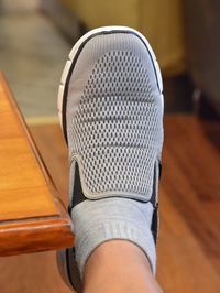 Low section of man wearing shoe at home