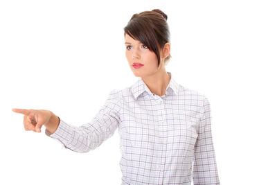 Portrait of young woman standing against white background