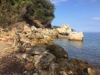 Rock formation in sea against sky