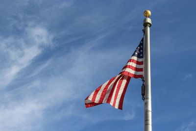 Low angle view of american flag against blue sky