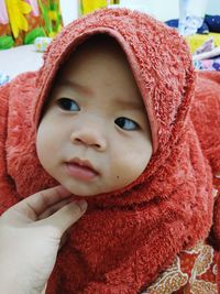 Cropped hand wearing cute baby girl hijab