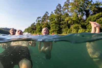 Rear view of people enjoying in water