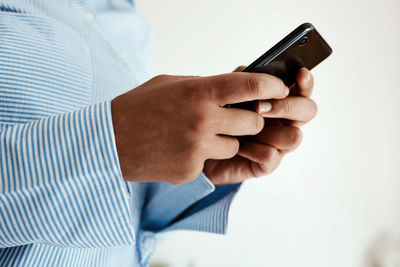 Midsection of man using mobile phone