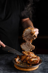 Close-up of person preparing food on barbecue grill