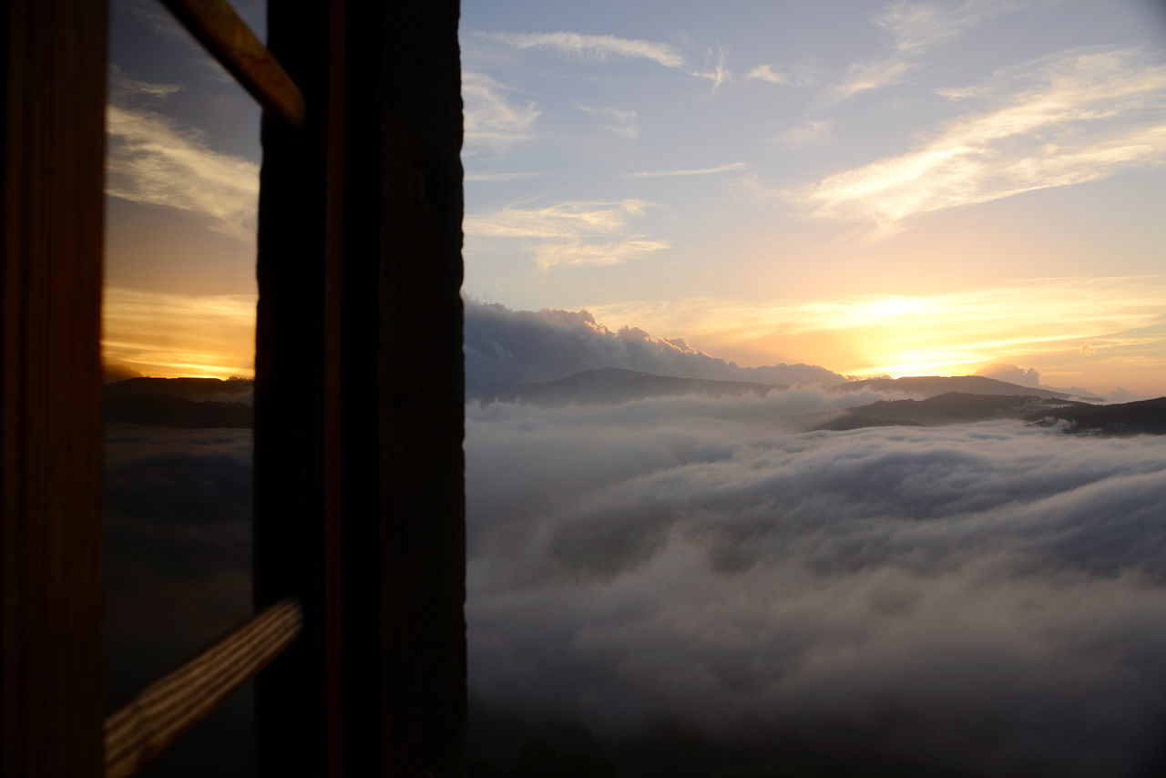 SCENIC VIEW OF DRAMATIC SKY SEEN THROUGH WINDOW DURING SUNSET