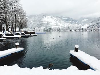 Scenic view of lake by snowcapped mountain against sky