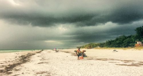 Scenic view of beach against cloudy sky