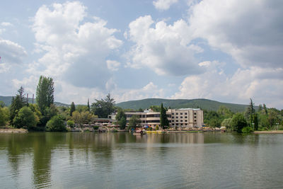 Scenic view of lake by buildings against sky