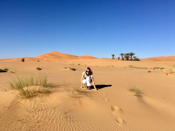 Full length of man on desert against clear sky