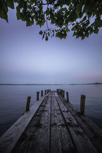 Wooden pier over sea against sky