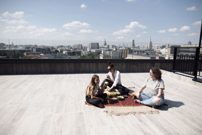 Woman with below-elbow amputation having a healthy meal on the roof with woman and girl
