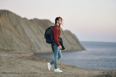 Full length of man standing on sea shore against sky