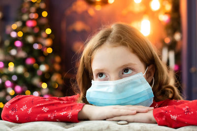 Portrait of a girl with christmas tree, mask, covid-19. 