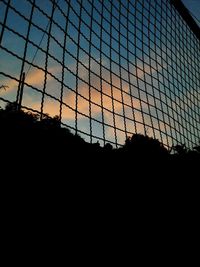 Low angle view of silhouette fence at sunset