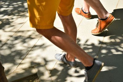 Low section of men walking on footpath