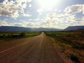 Empty road passing through field