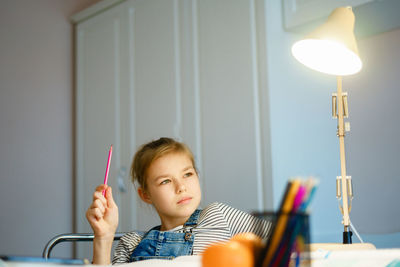 Portrait of cute girl looking at home