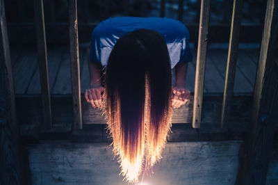 Rear view of woman standing by fire