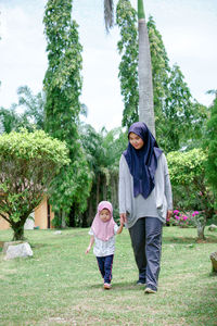 Portrait of smiling couple walking on field