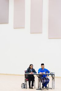Young couple sitting on wall