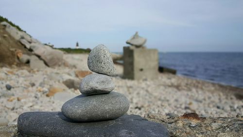 Stack of pebbles at beach against sky